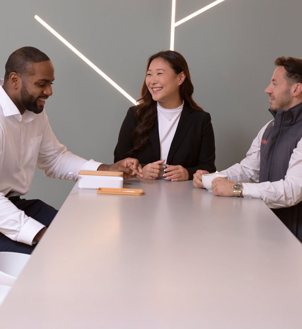 3 Kyndryl employees discussing a project over a coffee
